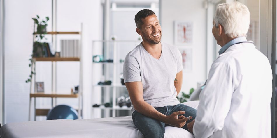 Man smiles while talking to his healthcare provider.